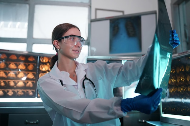 Portrait of young doctor checking XRay in hospital to make diagnosis