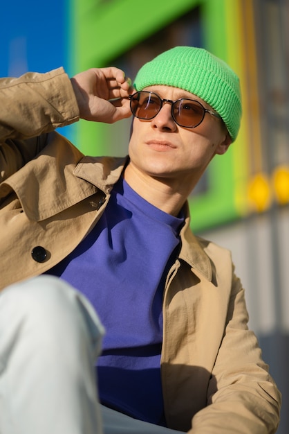 Portrait of a young elegant boy, wearing sunglasses, sitting