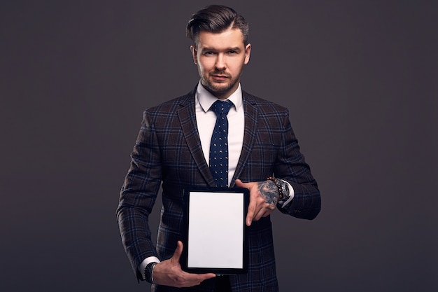 Portrait of a young elegant brutal man with tablet