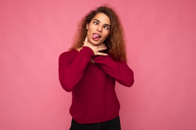 Portrait of young emotional beautiful brunette curly woman with sincere emotions wearing trendy pink