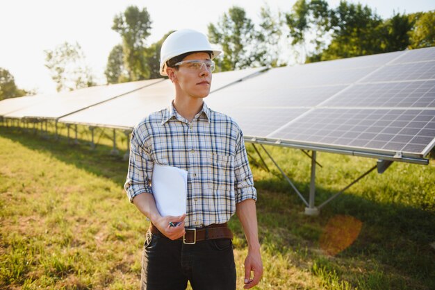 The portrait of a young engineer checks photovoltaic solar panels  