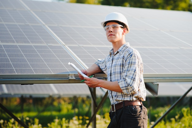 The portrait of a young engineer checks photovoltaic solar panels 