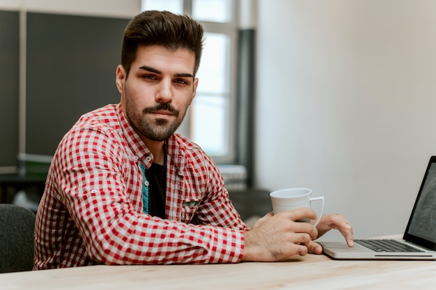 Portrait of young entrepreneur at his workplace.