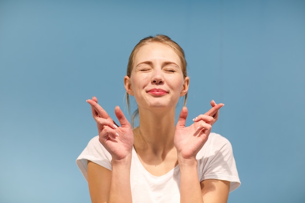 Portrait of a young European woman with blond hair. She closed her eyes and smiles.