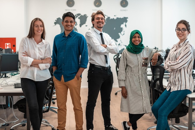 Portrait of young excited multiethnics business team of\
software developers standing and looking at the camera at modern\
startup office. high-quality photo