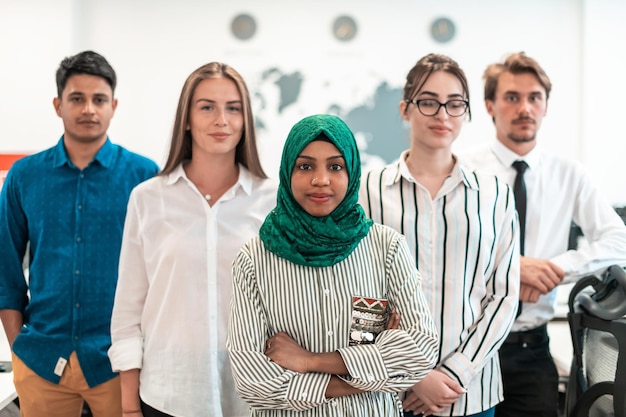 Portrait of young excited multiethnics business team of\
software developers standing and looking at the camera at modern\
startup office. high-quality photo