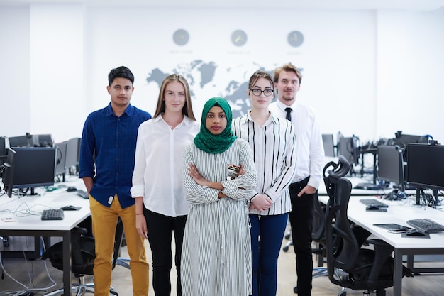 portrait of young excited multiethnics business team of software developers standing and looking at camera at modern startup office