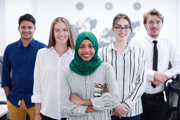 Portrait of young excited multiethnics business team of\
software developers standing and looking at camera at modern\
startup office