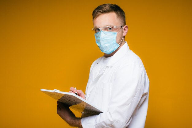 Портрет молодого измученного врача в синей медицинской маске на лице