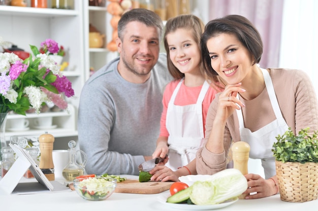 Portrait of young family cooking together at kitchen