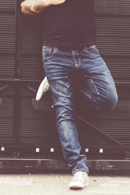 Portrait of young fashion handsome hipster man in blue denim jeans