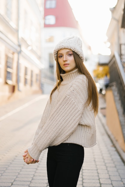 Portrait of a young fashionable woman dressed in a knitted warm sweater and hat