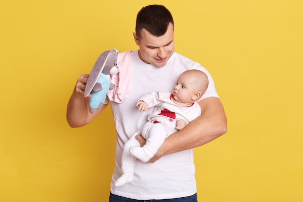 Photo portrait of young father holding his newborn baby in hands