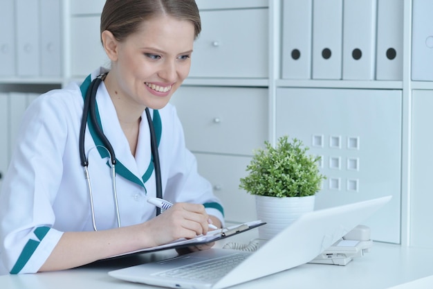 Portrait of a young female doctor using laptop