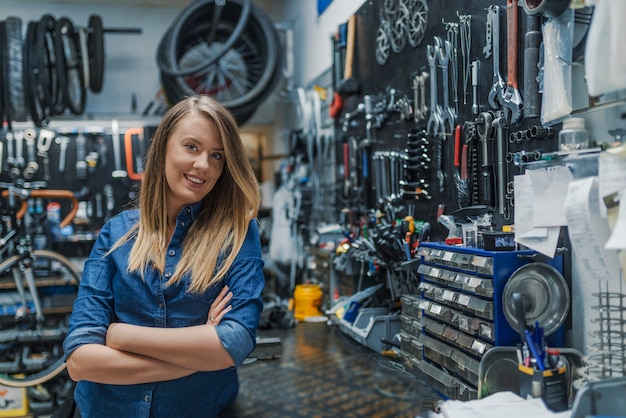 Portrait of young female mechanic in bicycle store