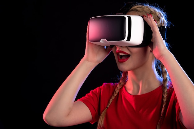 Portrait of young female playing virtual reality on dark wall