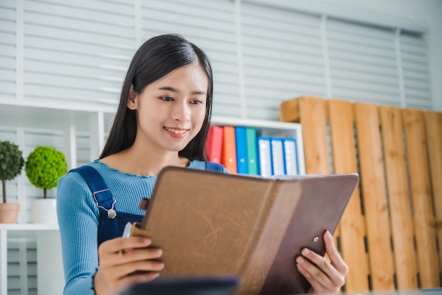 Portrait of young female smile charming lady with notebook paper, attractive asian woman feeling happy.