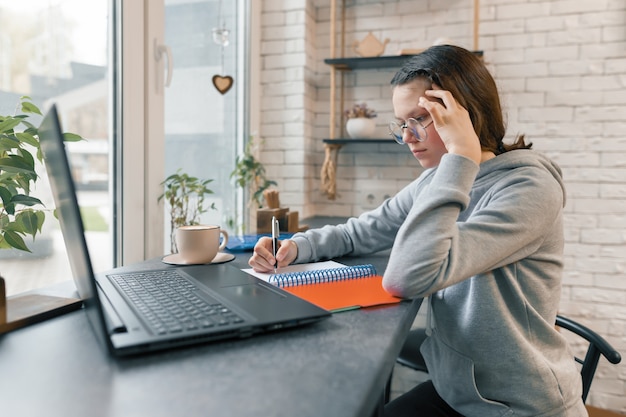 Portrait of young female student in coffee shop with laptop