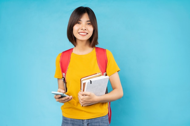 Portrait of young female student, isolated on blue background