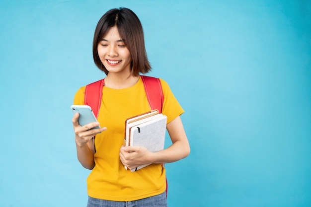 Portrait of young female student isolated on blue background