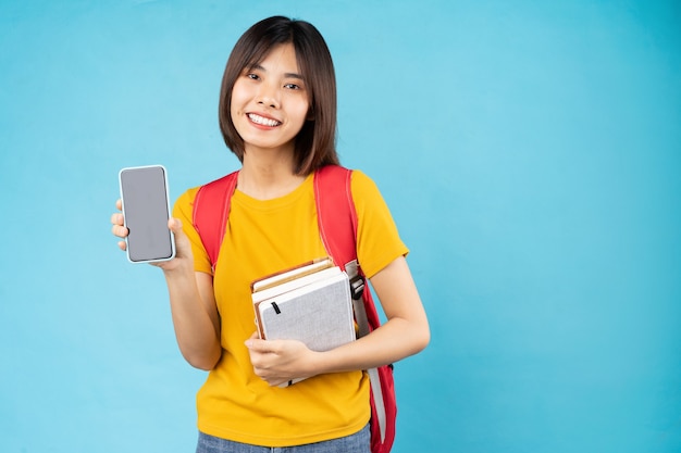 Portrait of young female student, isolated on blue background