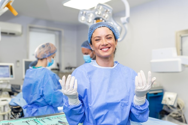 Ritratto di giovane medico chirurgo femminile circondato dal suo team gruppo di chirurgo in sala operatoria