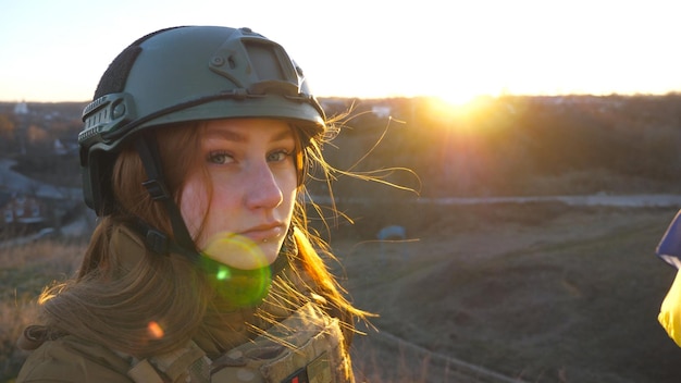 Portrait of young female ukrainian army soldier Sad emotion on face of girl in military helmet during war in Ukraine Russian aggression in Europe Invasion resistance concept Close up