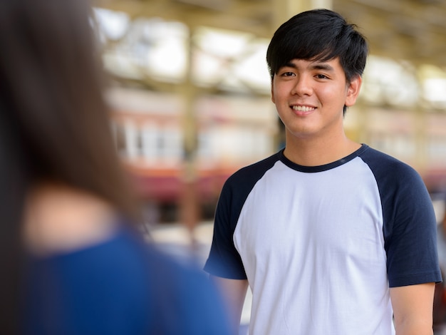 Portrait of young Filipino tourist man and young Asian tourist woman together and in love at Hua Lamphong railway station