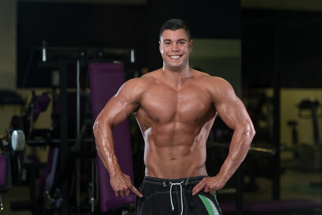 Portrait Of A Young Fit Man Showing His Well Trained Body  Muscular Athletic Bodybuilder Fitness Model Posing After Exercises