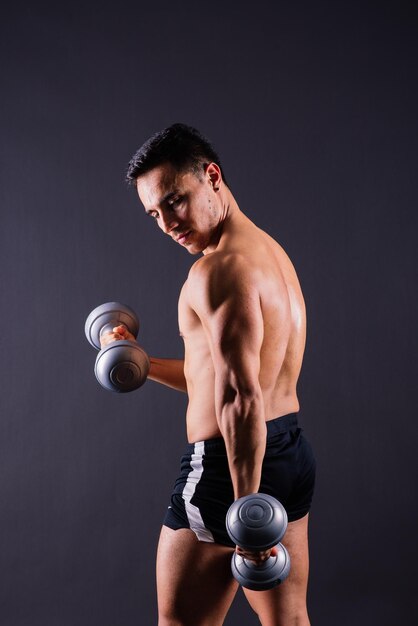 Portrait young fitness sporty strong man barechested muscular sportsman isolated on grey dark