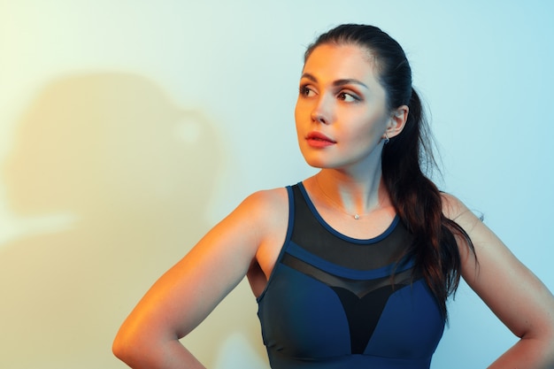 Portrait of a young fitness woman in sportswear posing in studio