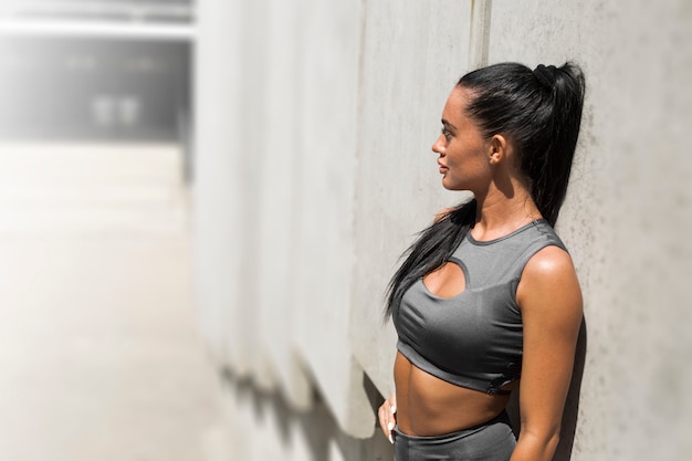 Photo portrait of a young fitness woman in stylish clothes