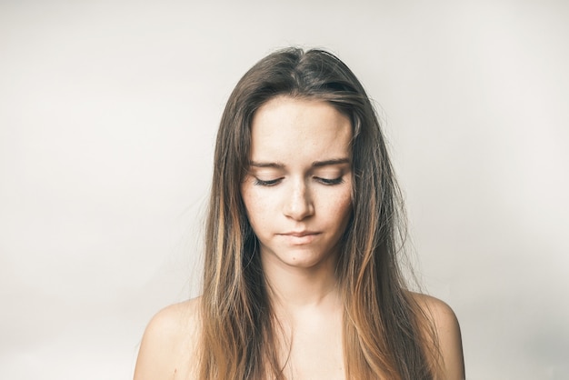 Portrait of a young frustrated woman with long hair, she looks down