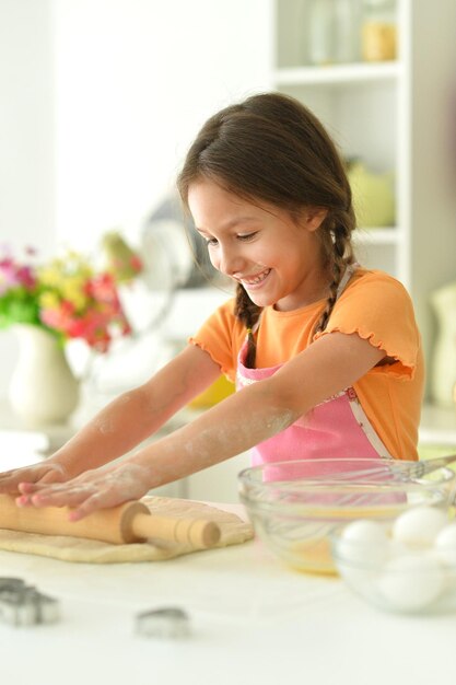 Photo portrait of a young girl baking in the kitchen