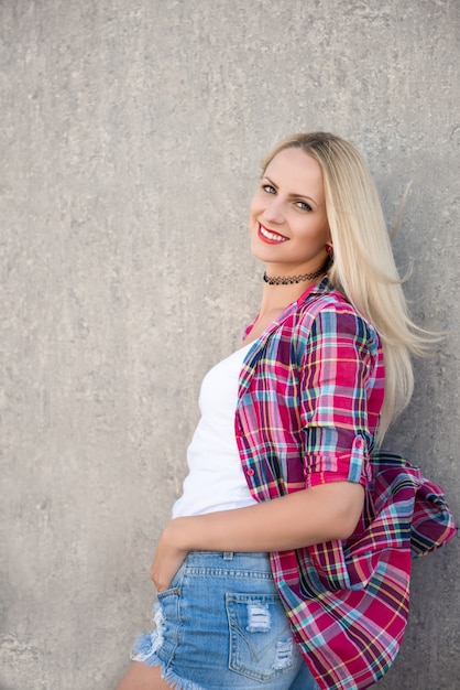 Foto ritratto di una giovane ragazza bionda con rossetto rosso con la maglietta