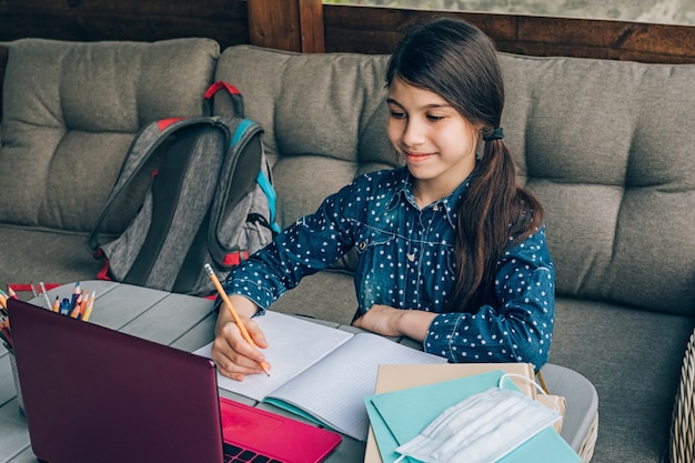 Photo portrait of a young girl doing homework