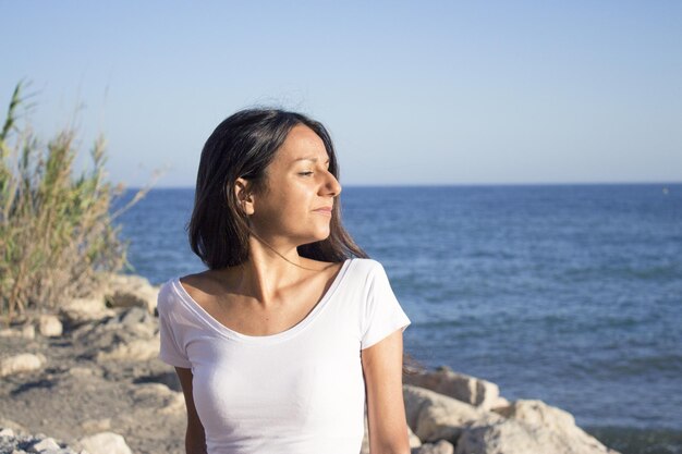 Foto ritratto di una giovane ragazza vestita di bianco con il mare sullo sfondo