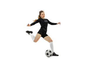 Portrait of young girl football player in motion training isolated over white studio background