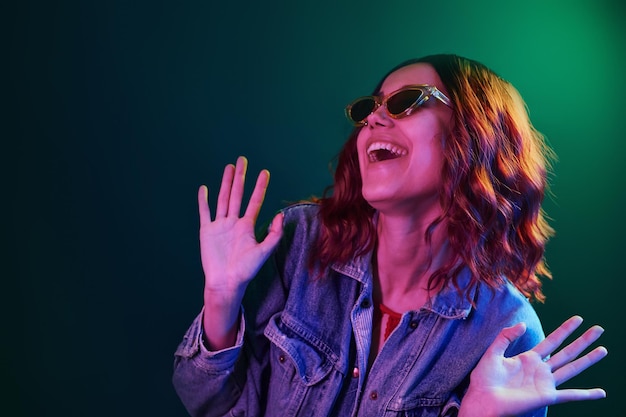 Portrait of young girl in glasses in red and blue neon in studio