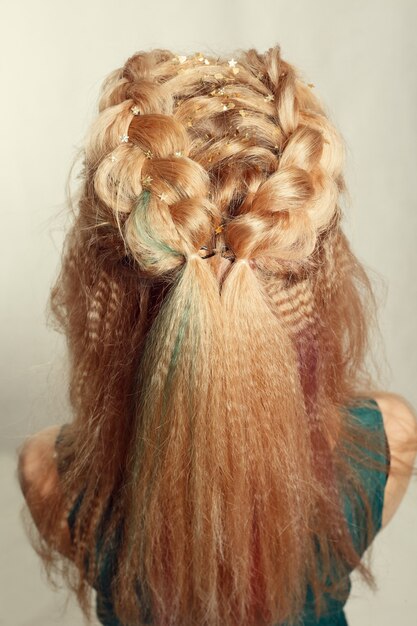 Photo portrait of young girl in green shirt with braided hair