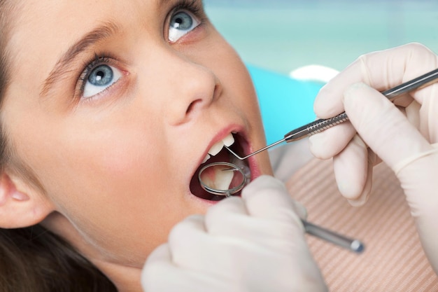 Портрет молодой девушки, проходящей обследование у стоматолога