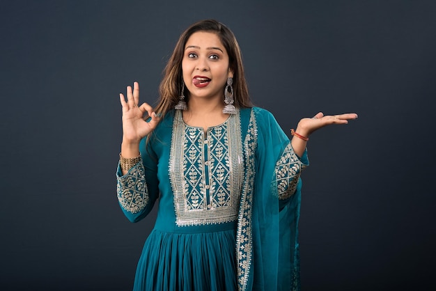 Photo portrait of a young girl holding and presenting something on hand with a happy smiling face