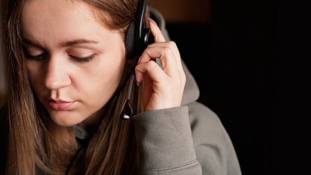 Portrait of a young girl in a hoodie and with a headset call center worker