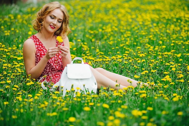 Portrait of a young girl in a Park in the dandelions