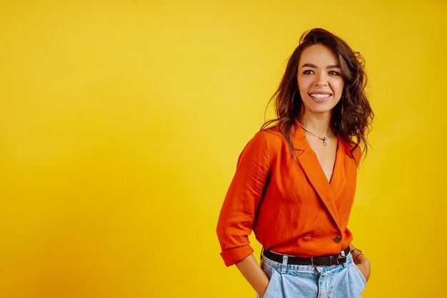 Portrait of young girl posing on yellow.