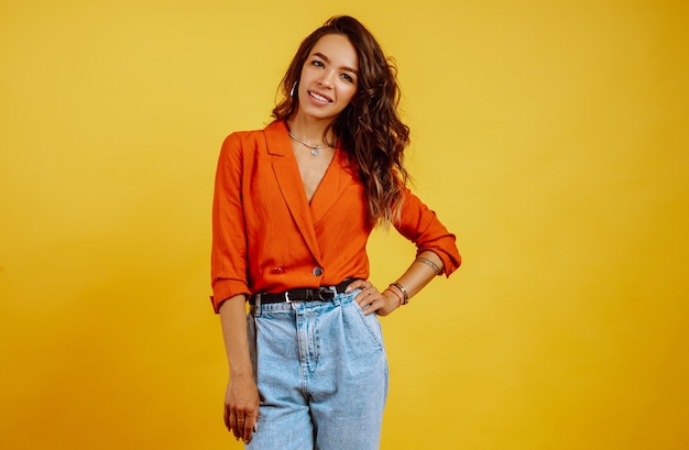 Portrait of young girl posing on yellow.