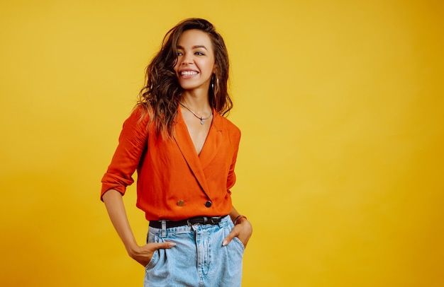 Portrait of young girl posing on yellow.