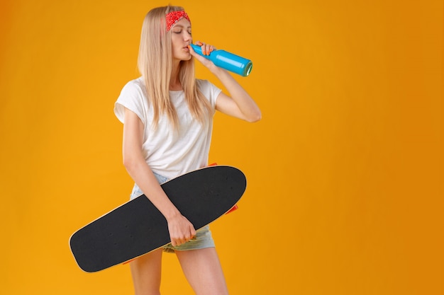 Portrait of a young girl in short shorts with longboard