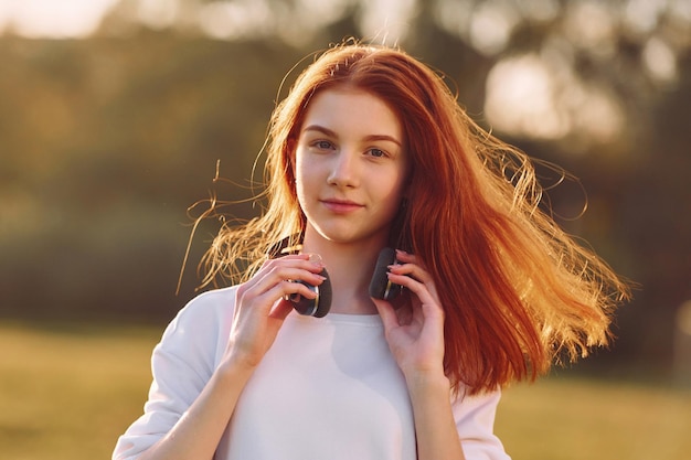 Portrait of young girl that is on the field at sunny daytime having nice weekend