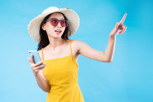 Portrait of young girl traveling, isolated on blue background